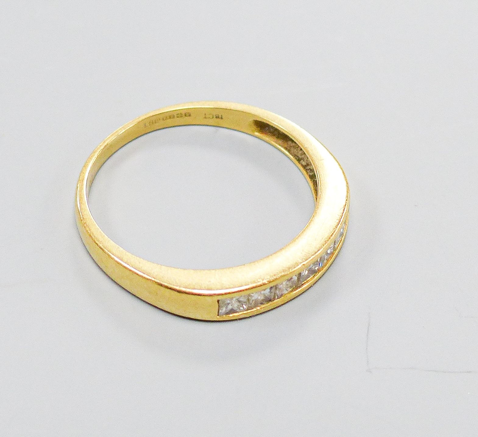 A modern 18ct gold and channel set seven stone diamond half hoop ring, size P, gross weight 2.8 grams.